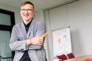 Wojciech Strózik, trener kompetencji miękkich, uśmiechnięty portret podczas szkolenia z komunikacji dla firm